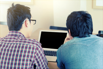 Two Asian freelancers in casual suit use laptop for discuss them project  at coffee shop cafe or modern office. Business and Office Concept.