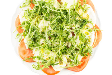 Fresh caprese salad on a plate isolated on white background flatlay.