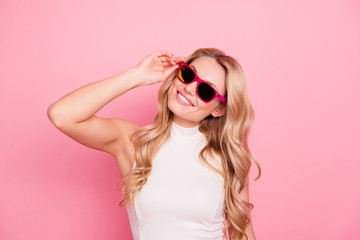 Portrait of lovely positive stylish girlfriend with beaming smile, fashionable successful confident chick in summer glasses holding eyelet with hand isolated on pink background
