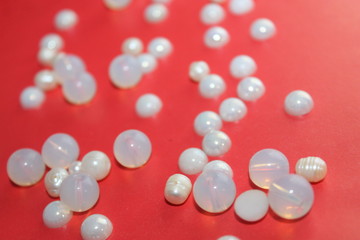 beautiful texture, blank for a postcard, romantic fashionable background, beads, pearls, lace tatters and knitting on a red background,