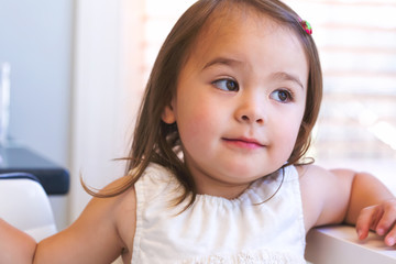 Portrait of a happy toddler girl sitting at a desk