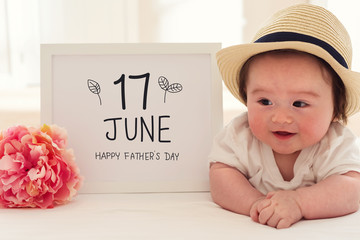 Father's Day massage with happy baby boy with a pink flower
