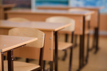 School classroom in blur background without young student; Blurry view of class room no kid or teacher with chairs and tables in campus.