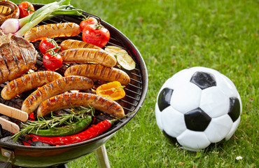 Steak, sausages and veggies grilling on a barbecue