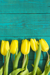 Beautiful fresh yellow  tulips on wooden background 