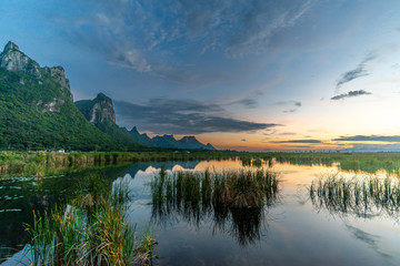 Naklejka na ściany i meble Pond and mountains under twilight evening colorful sky in Thailand