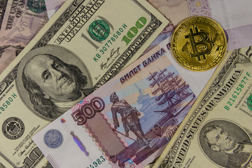 Golden bitcoin on background of us dollars and russian rubles
