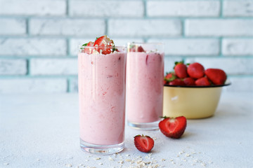 Strawberry smoothies with yogurt or milk and oatmeal. Spring or summer seasonal breakfast in glass on  white background