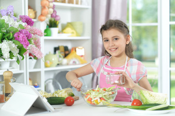 Cute little girl making dinner