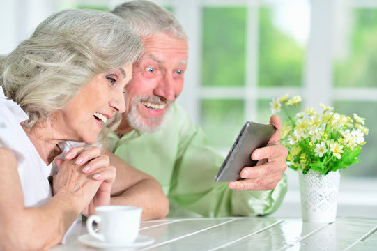 portrait of happy beautiful senior couple using tablet 