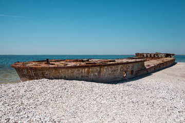 Sunken ship on a sea beach on white sand