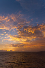 summer sunset colorful sky with dramatic  purple red and yellow clouds over picturesque water landscape. Bali, Indonesia.