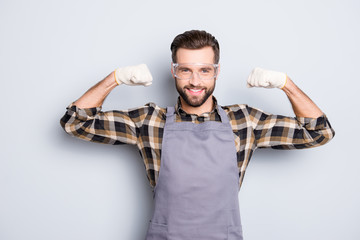 Portrait of sportive athletic carpenter in safety glasses with hairstyle demonstrate his biceps...