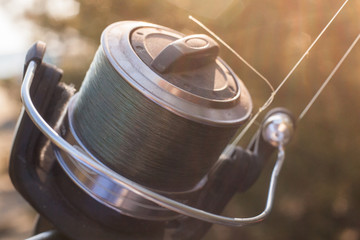 Fishing coil with fish line closeup - obrazy, fototapety, plakaty