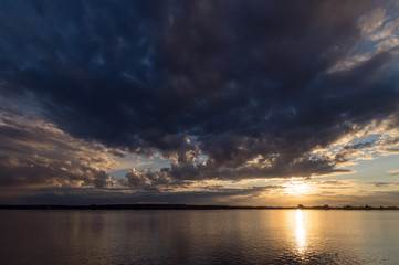 Big cloud over the Tom river in the light of sunlight
