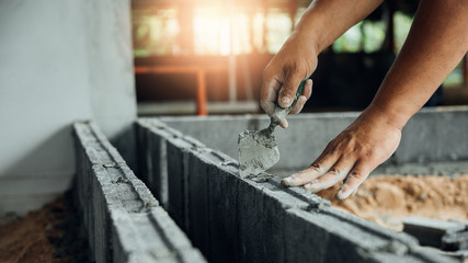 blue collar workers working in factory,Worker builds a brick wall.