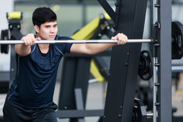 Young man posing and doing exercises in the gym.