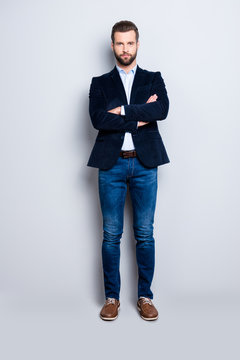 Full size body portrait of handsome virile teacher with stubble having his arms crossed looking at camera isolated on grey background, wearing jacket jeans shirt