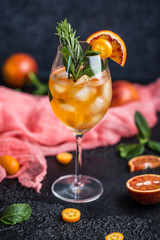 Cocktail with orange juice and ice cubes. Glass of orange soda drink on dark background 
