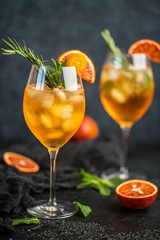 Cocktail with orange juice and ice cubes. Glass of orange soda drink on dark background 