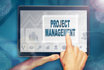 A hand selecting a Project Management business concept on a computer tablet screen with a colorful background.