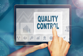 A hand selecting a Quality Control business concept on a computer tablet screen with a colorful background.