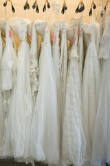 white wedding dresses hanging on racks