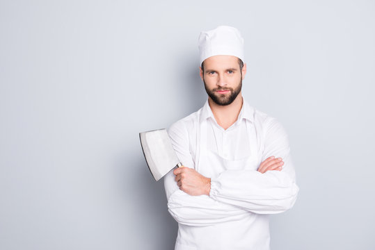 Portrait of handsome attractive butcher in beret having his arms crossed holding metal cleaver looking at camera isolated on grey background