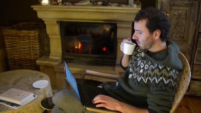 A Man use Laptop working outsource at Home near Fireplace