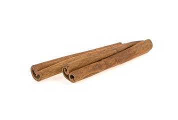 two cinnamon sticks on a white background