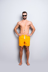 Full size body portrait of muscular athletic lifeguard with stubble in yellow shortsisolated on...
