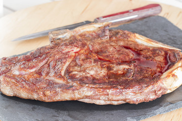 A steak on the rectangular slate dish.