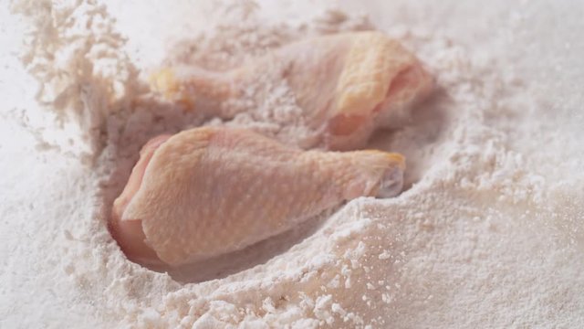 Fresh raw chicken drum dropped into flour. Shot with high speed camera, phantom flex 4K. Slow Motion.