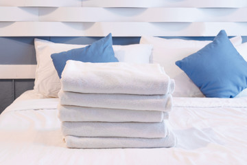 Clean towels on the bed in hotel room.