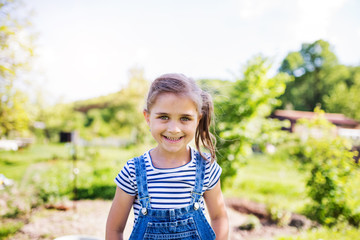 A portrait of a small girl in the garden in spring nature.