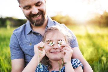 Father with a small daughter having fun in spring nature.