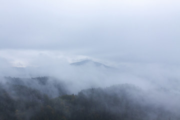Peaks of mountains surrounded by clouds and fog