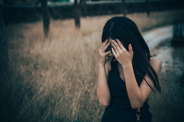 Portrait of lonely woman alone in a field. Vintage filter style.she heartbreak from love,sad girl concept on sunset vintage style