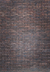 Vertical dark red brick wall background, wallpaper. Red bricks pattern, texture.. Vignette background