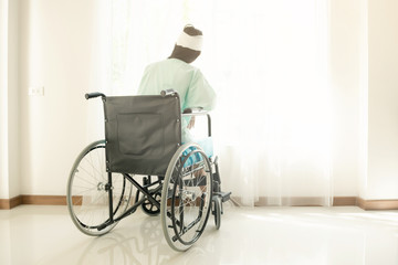 Young woman in hospital wheel chair. Looking at window. Beautiful chinese woman. Medical, health insurance concept.