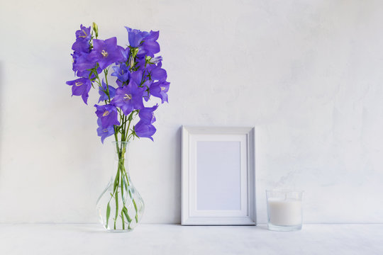 Mockup with a white frame and summer blue flowers