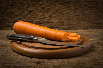 carrot sliced with knife on wood chopping Board  on old wood