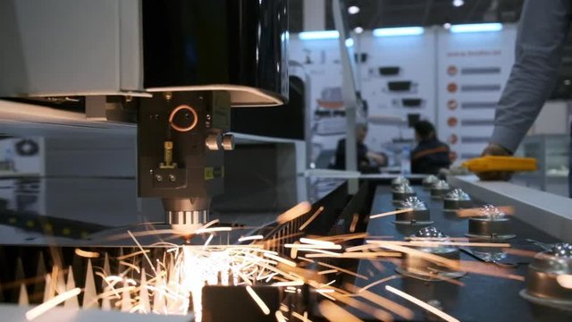 Industrial robotic laser cutter cuts metal parts with great precision.
