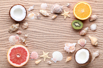 Seashells and starfishes with fruits on beach sand