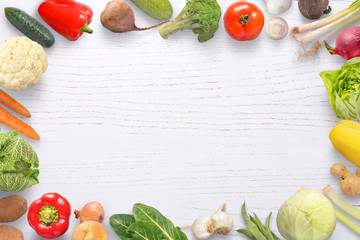 Vegetables composition on white wooden background with copy space in the middle.