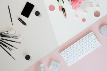 Beauty flat lay with a white computer keyboard, cosmetic, flowers, palm leaf, vintage camera. Top view composition. Copy space. Pastel trendy background, beauty concept