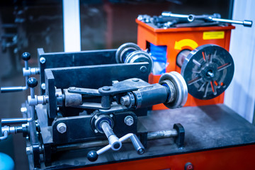 Fototapeta premium Repair of wheels. Machine for repairing wheel disks. Edit curved wheels. Equipment for auto workshop. Repair of wheel disks of a motor vehicle.