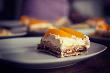Homemade cream cake with peaches, closeup with shallow depth of field. vignetting and toning effect