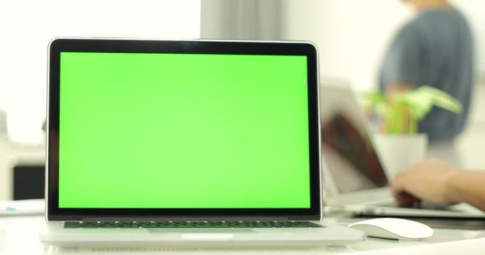 Green laptop computer screen set in front of workgroup