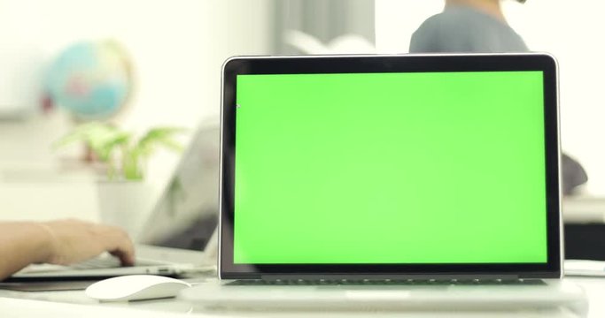 Green laptop computer screen set in front of workgroup